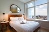 a bedroom with a bed and a large window