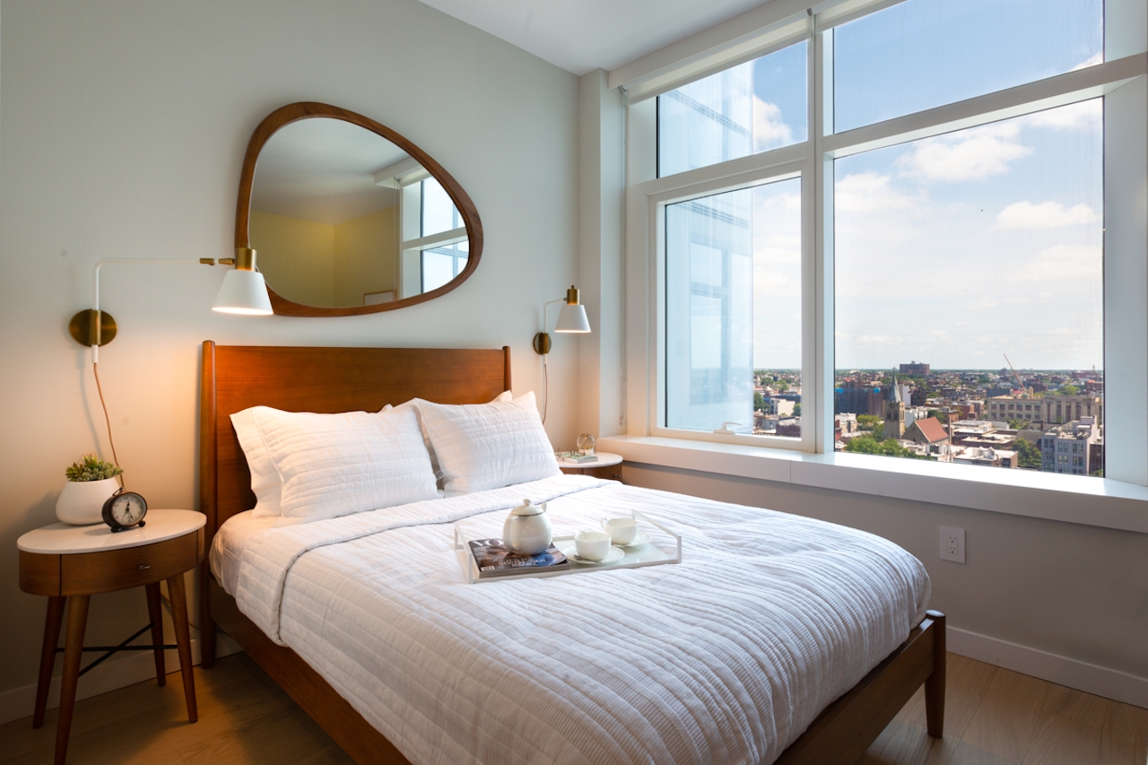 a bedroom with a bed and a large window